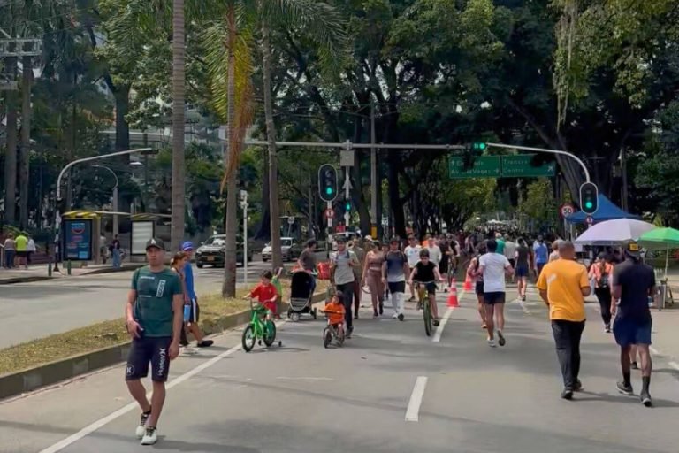 People enjoying Ciclovia in Medellin on a sunny Sunday, walking and biking on closed streets