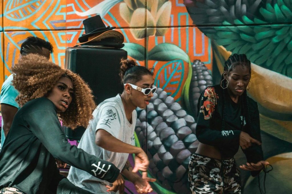 Afro-Colombian performers dancing in front of a mural in Comuna 13 Medellin