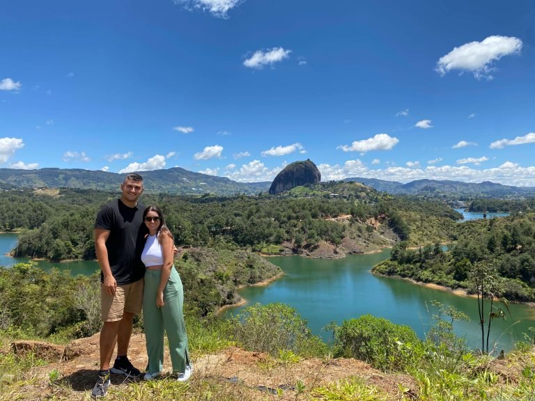 Couple at a scenic viewpoint during a Guatape day trip from Medellin, with El Peñol rock in the background